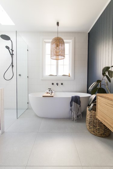White bathroom with navy wall and rattan hanging light