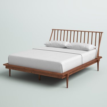 Mercury Row Henline Solid Wood Spindle Bed with white sheets and pillows.