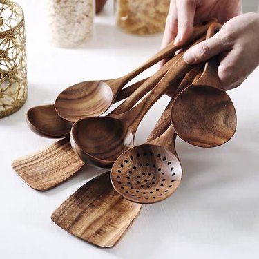 Person holding wooden utensils