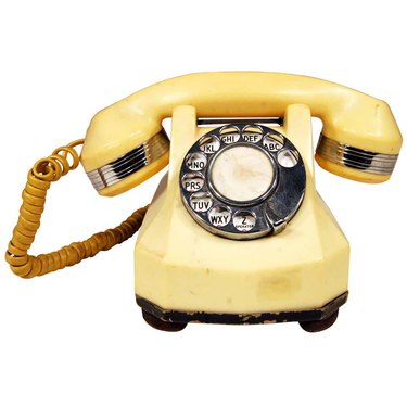 Old yellow telephone with dial