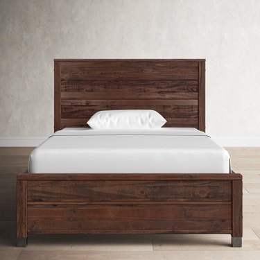Birch Lane Clove Solid Wood Bed Frame with white pillow and sheet on the bed.