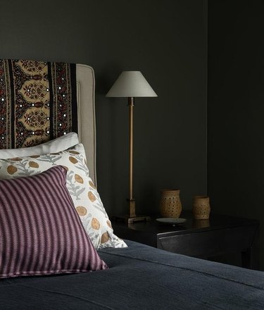 bedroom with black walls and floral pillows