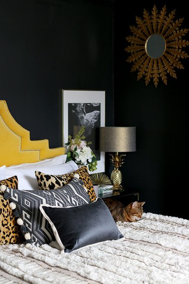 bedroom with black walls and leopard print throws
