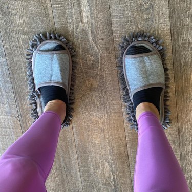 person wearing grey mop slippers