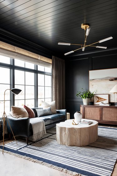 black living room with patterned area rug