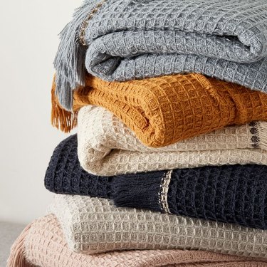 pile of waffle throw blankets in various colors