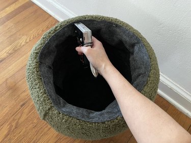 Stapling gray felt fabric inside bucket to create a finished lining
