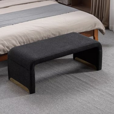 curved black boucle bench with metal legs