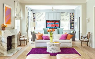 jewel-toned living room with fuchsia rug layered