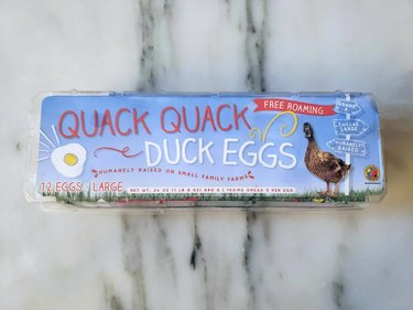 Carton of duck eggs on a white marble countertop