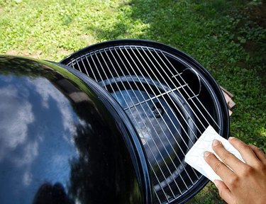 Cleaning the grill grate with a Mr. Clean Magic Eraser cleaning pad.
