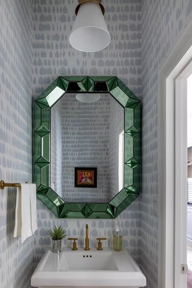 Small powder room with a green glass mosaic mirror above the sink