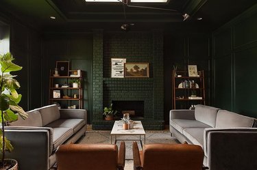 seating area with dark greens walls and fireplace