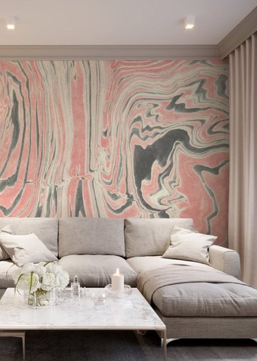 sectional sofa near coffee table with pink swirly-patterned wallpaper