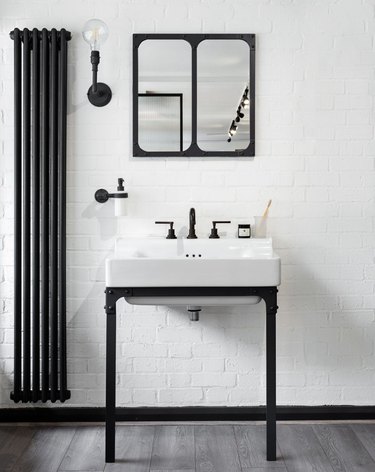 black-and-white industrial bathroom with exposed radiator