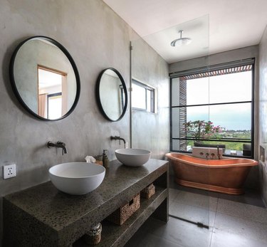 copper bathtub in industrial bathroom with ocean views