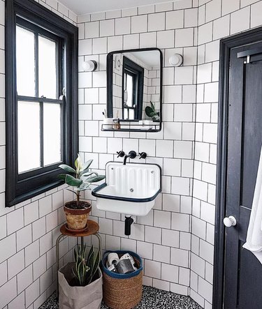 black-and-white small industrial bathroom with dark grout and square tile