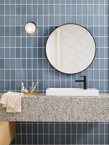 blue tile bathroom wall with gray speckled counters