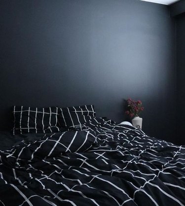 bedroom with black walls and graphic black and white bedding
