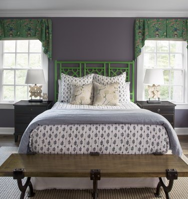 Purple and green bedroom with green bamboo headboard, block print bedding, and green Chinoiserie print window valances