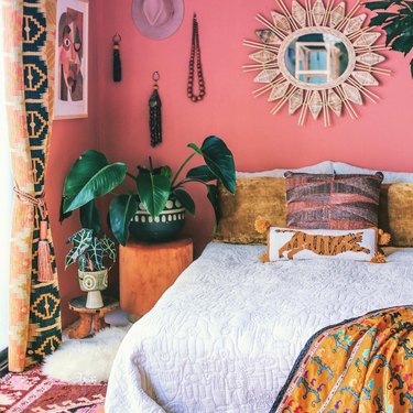 Bedroom with bohemian and global accents in pink, orange, and white.