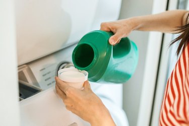 Woman pouring laundry detergent in the cap