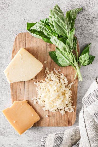 Cheese and basil on wooden board