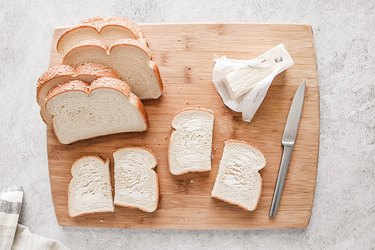 Sliced bread with butter on a wooden cutting board