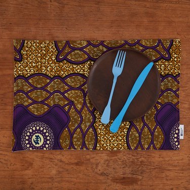 tabletop with patterned placemat and plate with blue utensils