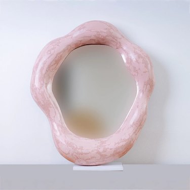 asymmetrical pink-framed mirror