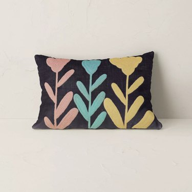 black pillow with floral design in various colors