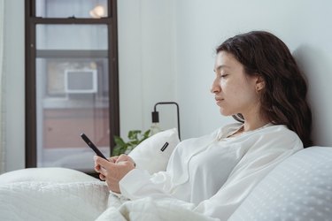 woman on phone in bed