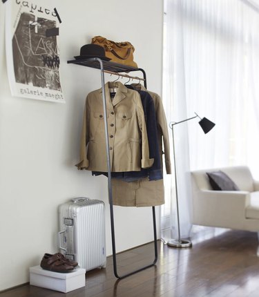 simple coat rack that leans on a wall in a neutral space