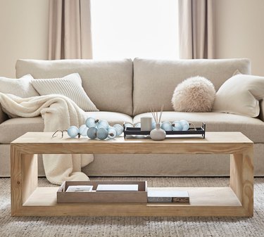 light wood coffee table with storage and couch