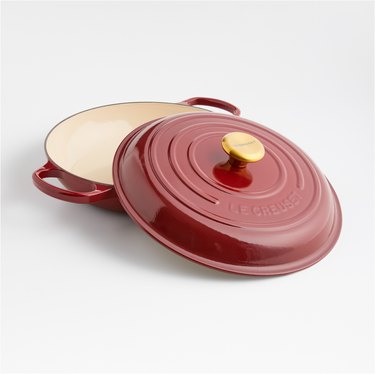 Classic 3.5-Quart Rhône Enameled Cast Iron Everyday Pan in a dark red color with a gold knob