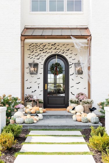 front porch with pumpkins, gourds and bats