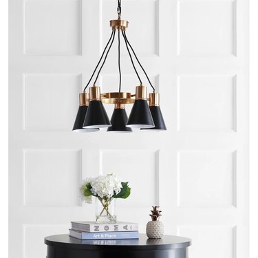 brass and black chandelier over black end table