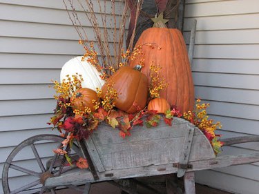 wooden wheel barrow filled with pumpkins