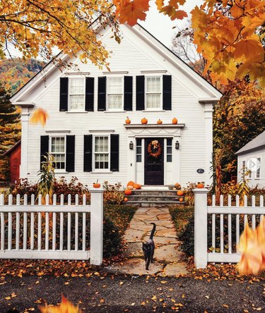 traditional home with pumpkin-lined portico