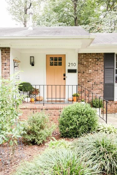 Brown brick house with a peach front door