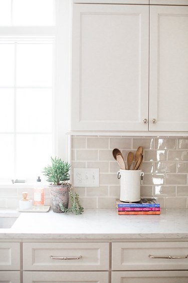 white cabinets with off-white tile backsplash
