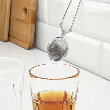 tea infuser over glass with tea