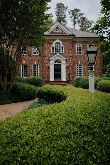 Brown brick colonial house with white trim