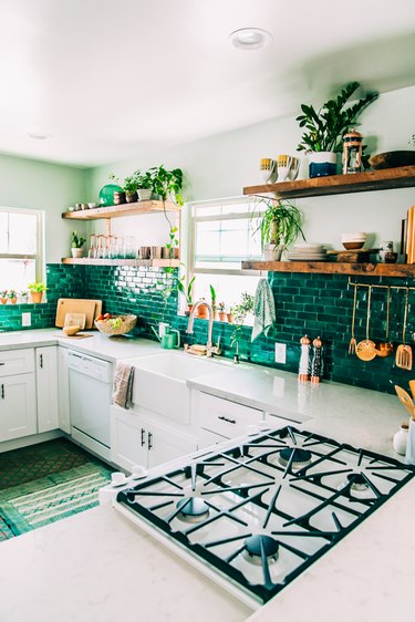 white cabinets with emerald tile backsplash