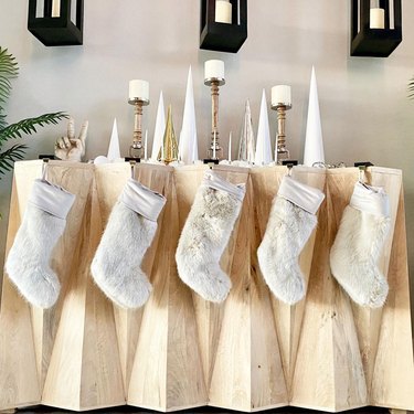 Five faux fur stockings hanging off a wooden display