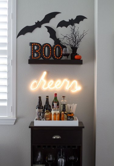 Bar cabinet with cheers neon sign and boo sign.