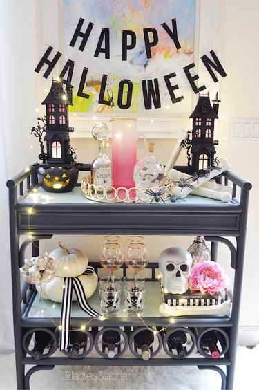 Bar cart with Halloween houses and a Happy Halloween sign.