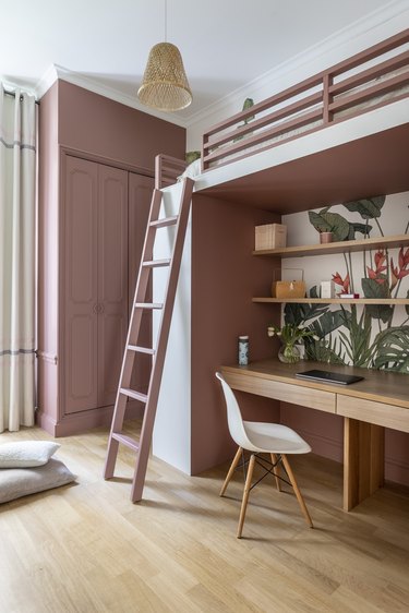 A pink kid's room with a lofted bed.