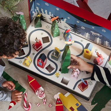 Two children playing with a holiday advent calendar.