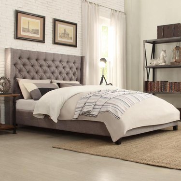 gray platform bed with tufted headboard